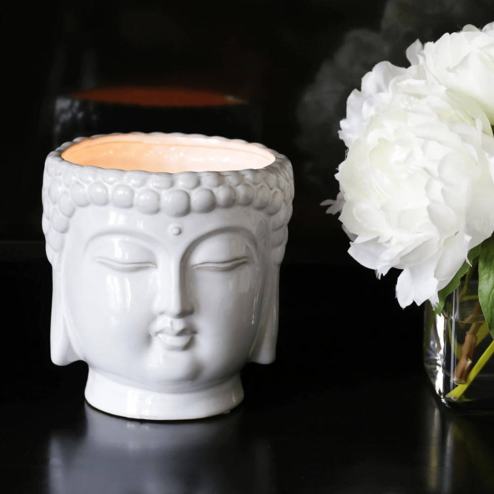 white ceramic buddha head candle with 3 cotton wicks