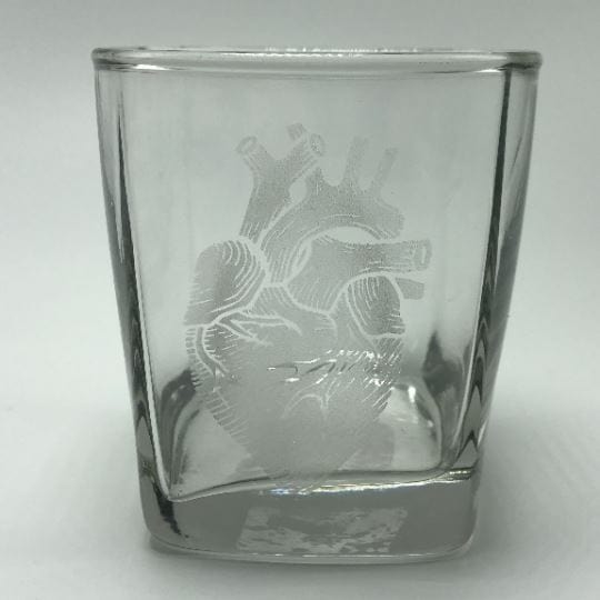 anatomical heart engraved soy candle in a rocks glass on white background